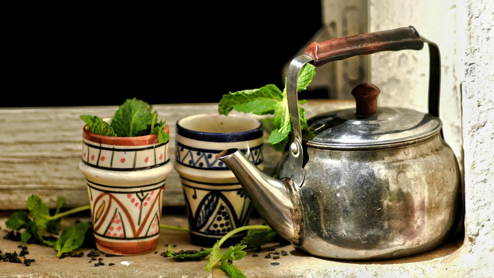 إبريق شاي تقليدي مع أكواب مزخرفة وأوراق نعناع طازجة – الشاي المغربي بالنعناع